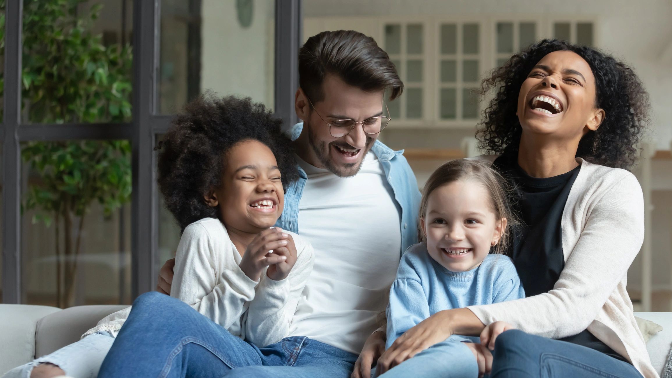 Parents and children relaxing together on a sofa at home